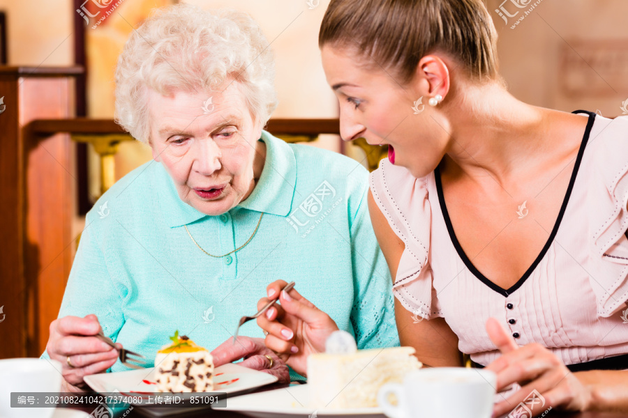 老太太和孙女在咖啡馆喝咖啡吃蛋糕