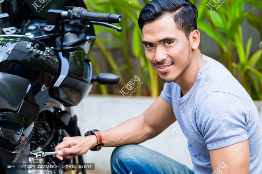 一名正在驾驶摩托车的亚洲人看着摄像机