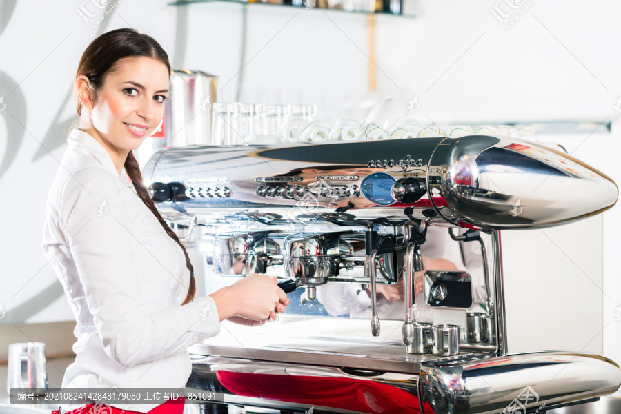 年轻的白人女服务员在使用自动咖啡机时看着摄像机