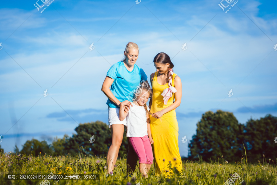 两个带着孩子的女人在草地上嬉戏