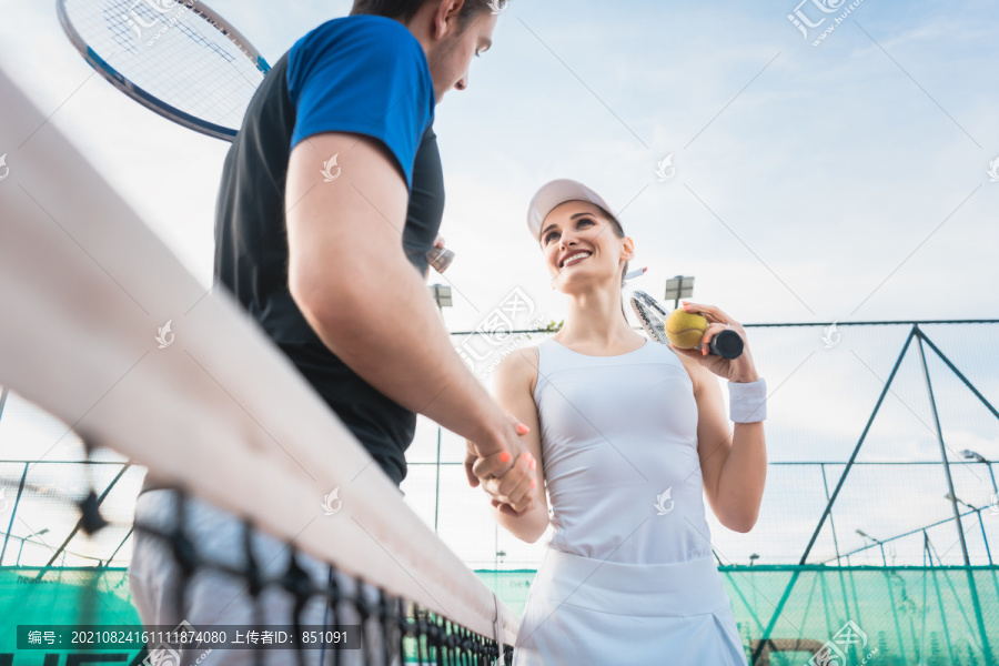 网球运动员男女在赛后在网前握手