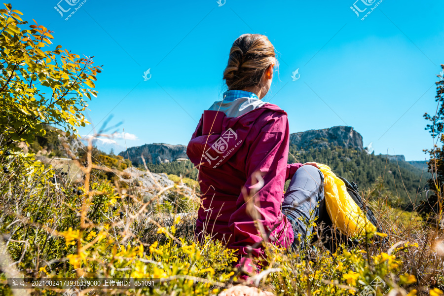 在春天，徒步旅行，观赏山峦、自然和美丽风景，休息的女人