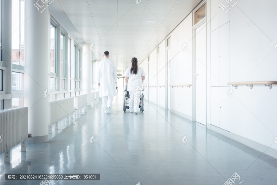 坐轮椅在医院走廊上行走的医生、护士和患者
