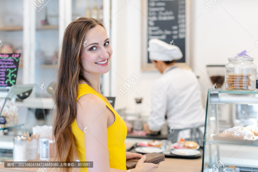 糕点店里的女人满怀期待地选择甜点