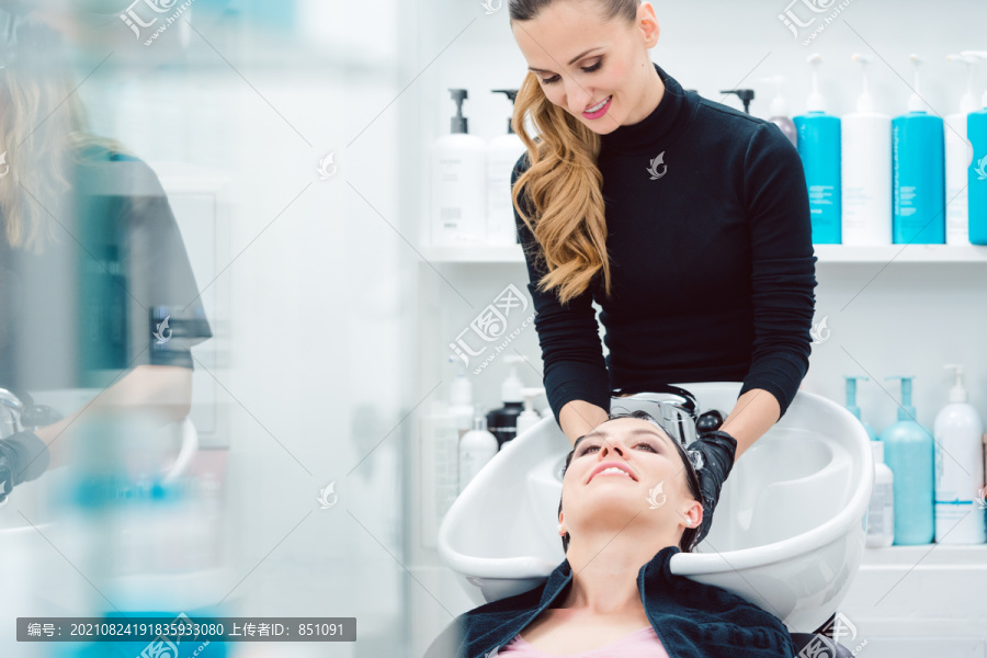 美发师勤勉地为顾客妇女洗头