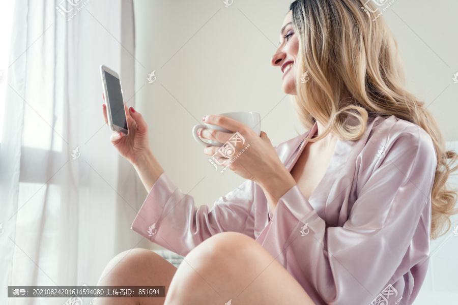 在臥室里用手機(jī)進(jìn)行早晨自拍的女人-匯圖網(wǎng) fosd68.com 在臥室里用手機(jī)進(jìn)行早晨自拍的女人