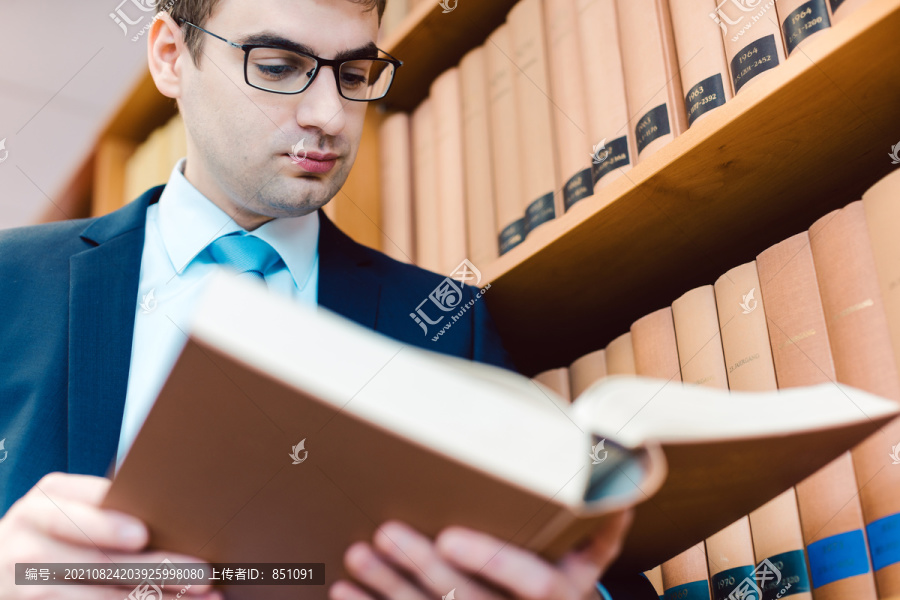 律师在办公室里读着厚厚的书中的先例，思考着一个案件