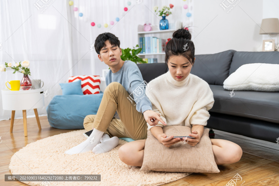 年轻情侣在家玩手机争吵