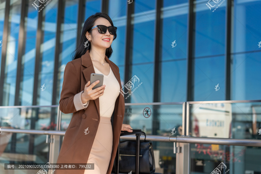商务女士在机场戴着太阳眼镜