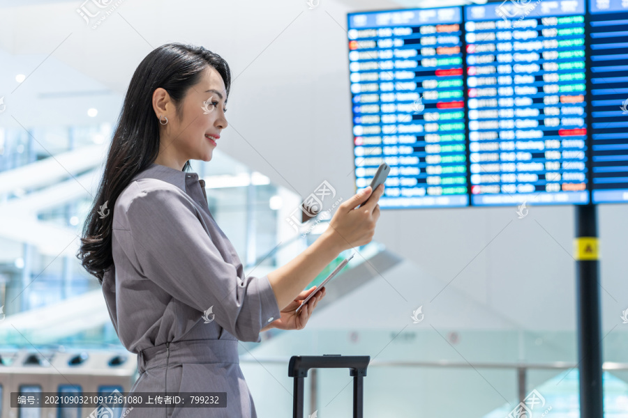 商务女士在机场使用手机