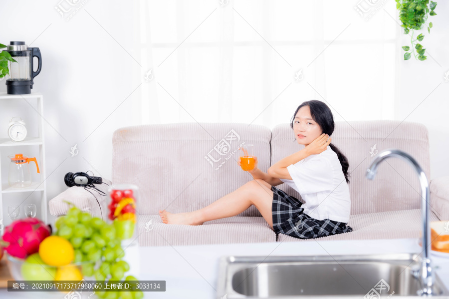 女士坐沙发喝果汁