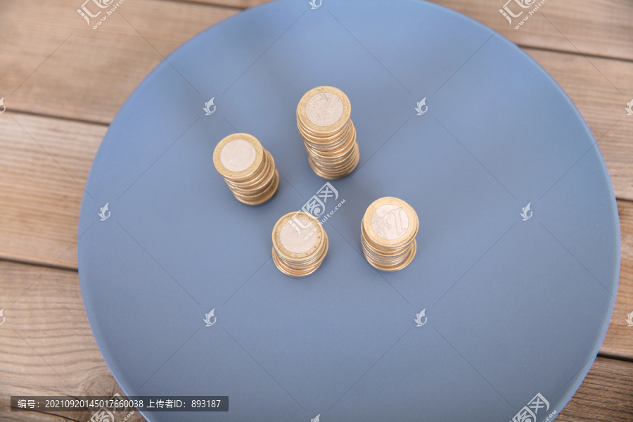 蓝色盘子里放着几摞欧元硬币