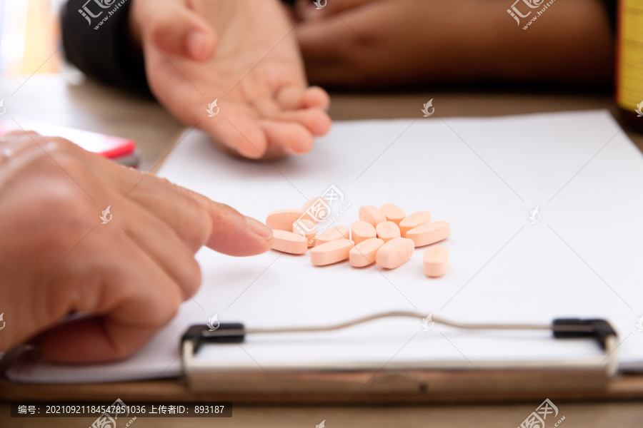 两个人在分析研究白纸上的药丸