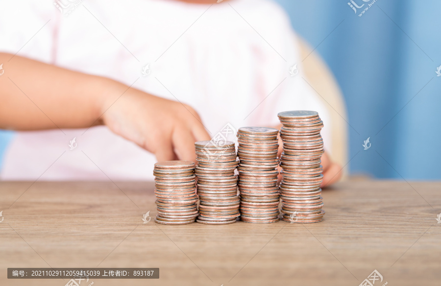 小孩子在摆放一排递增的美元硬币