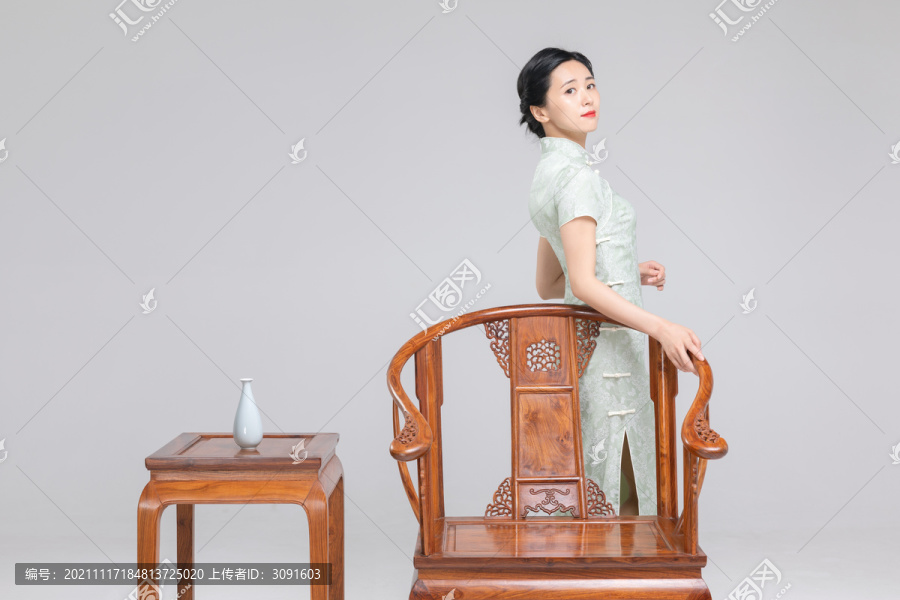 站在椅子旁的旗袍美女