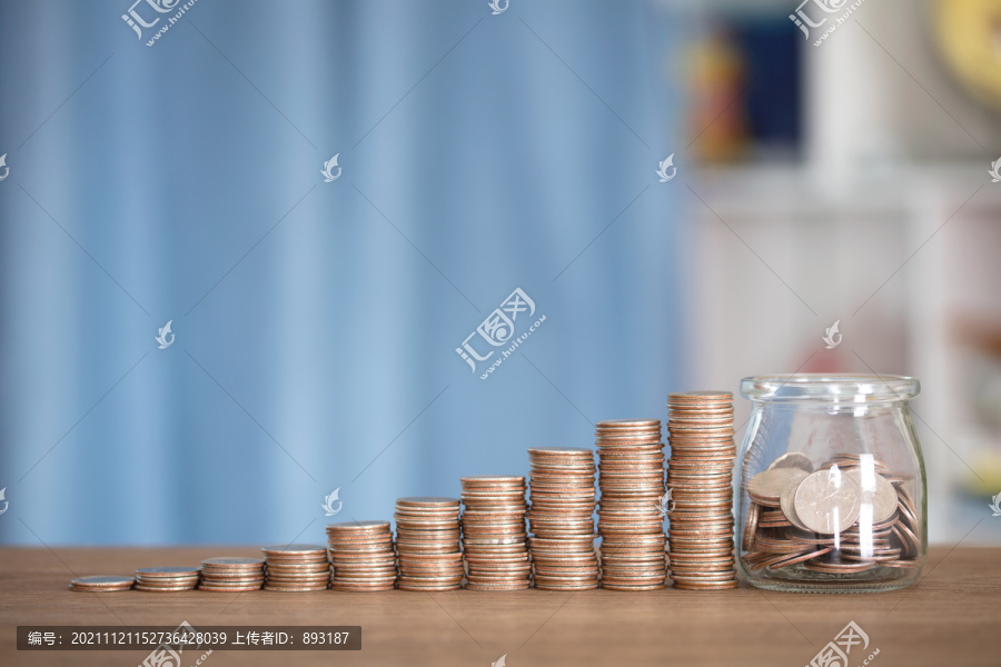 一排递增的美元硬币和玻璃储蓄罐