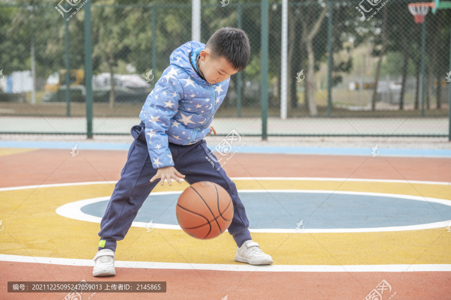 学校操场上打篮球的小男孩