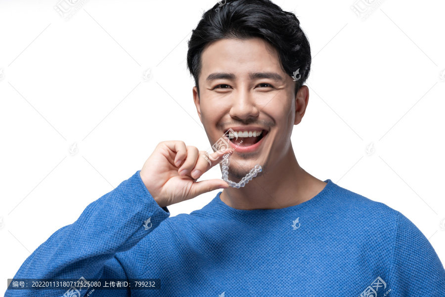 年轻男子拿着透明牙套
