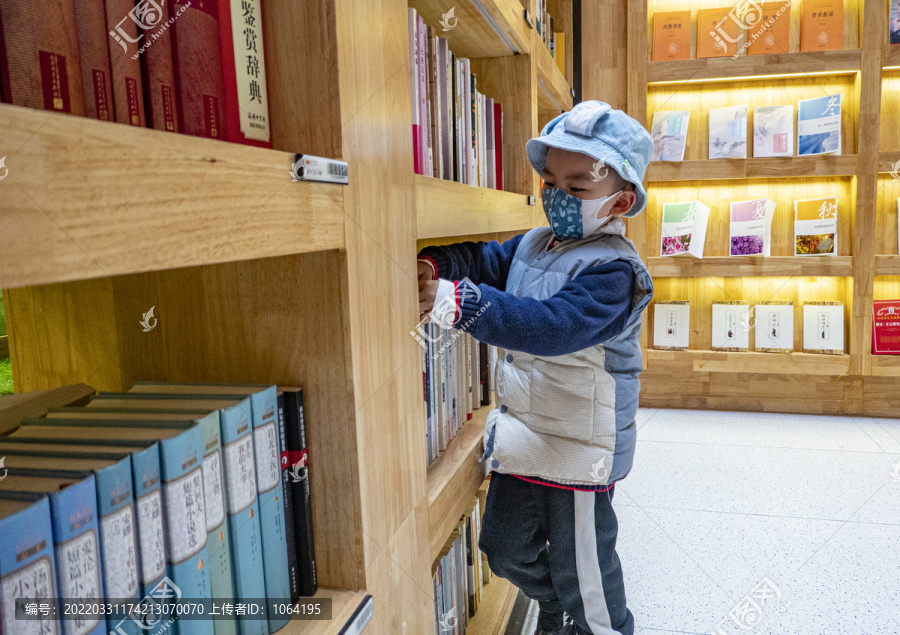 在书架前挑选书本的孩子