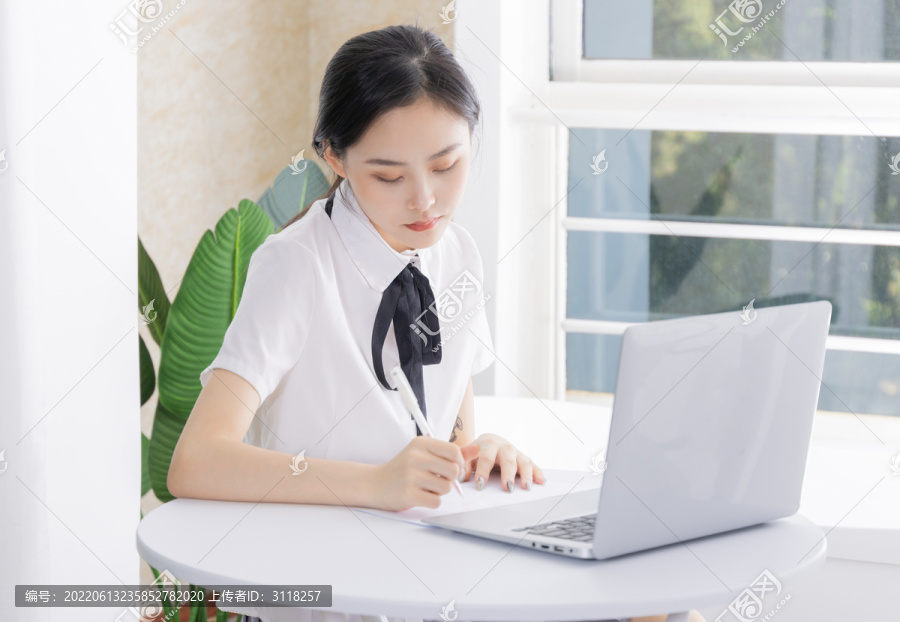 亚洲女性在电脑前写字办公