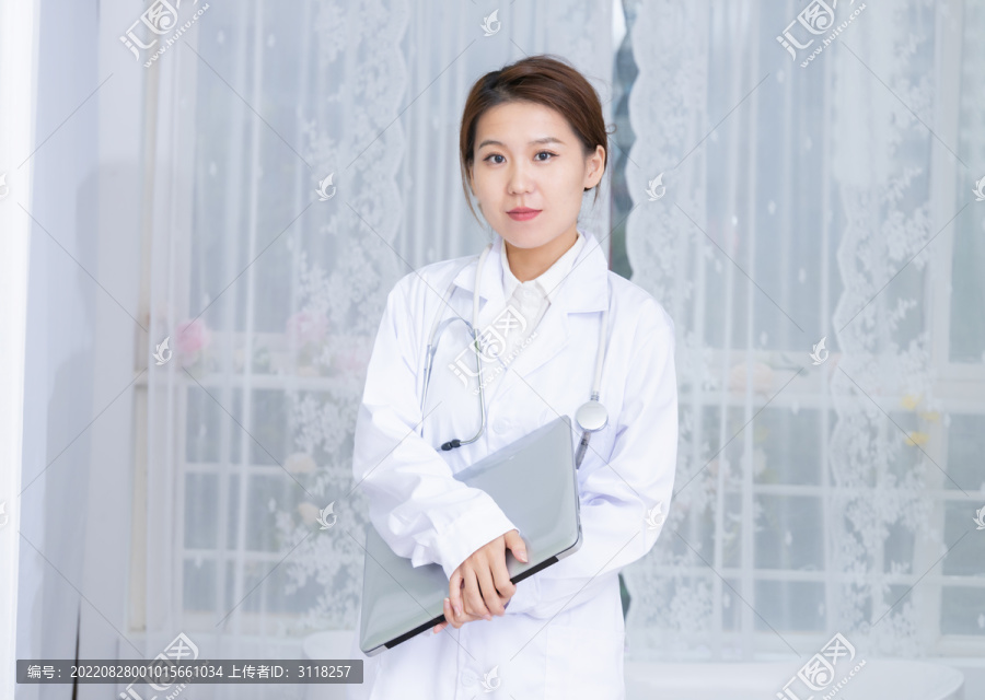 室内女医生手持笔记本电脑