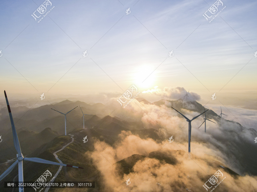 日出下云雾缭绕风力发电大风车