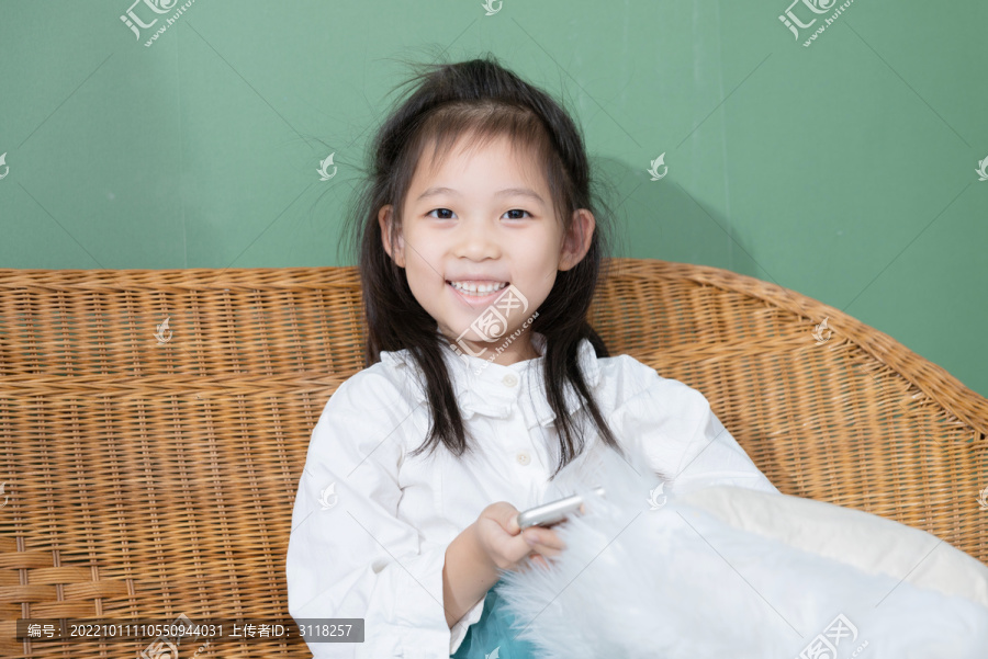 躺椅上微笑玩手机的小女孩