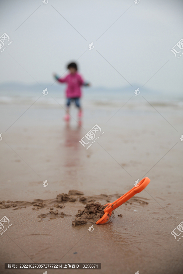 一个小女孩在沙滩上玩沙子