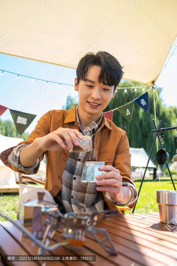 男孩坐天幕下煮咖啡