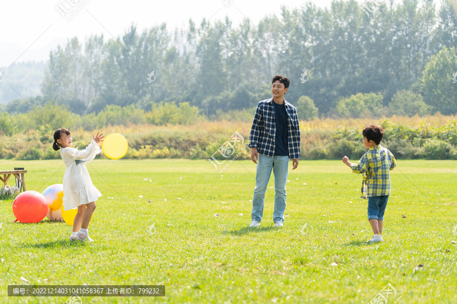 爸爸和孩子在草地上扔飞盘