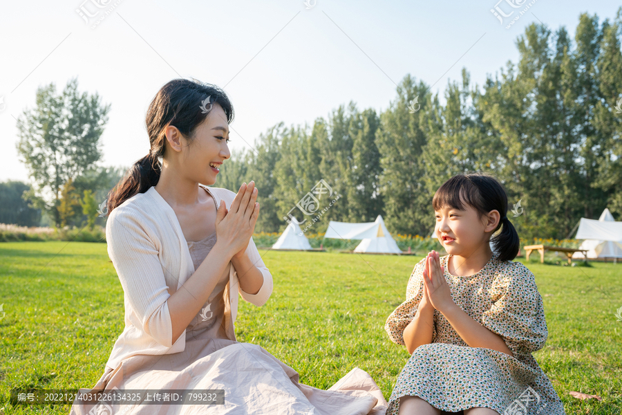 妈妈和女儿在草地上做游戏