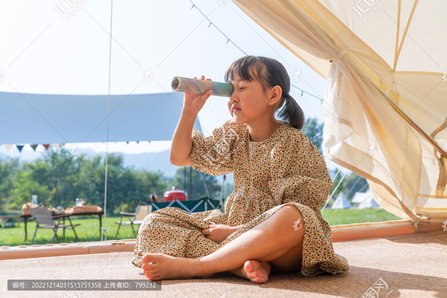 一个女孩坐在帐篷里玩耍
