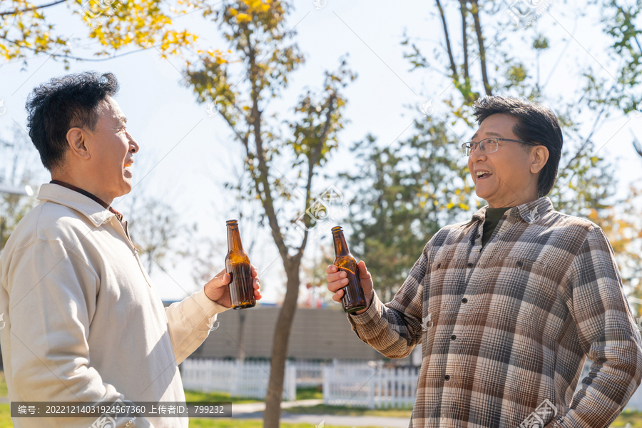 两个老年男人站在露营地喝啤酒