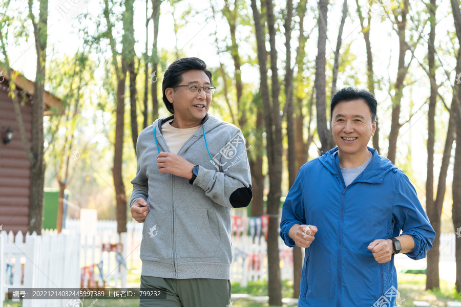 两戴运动手表的中老年男人在树林里跑步健身