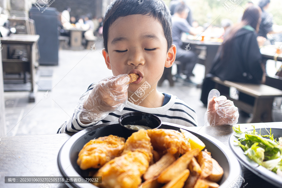 小男孩满足地吃炸鸡薯条