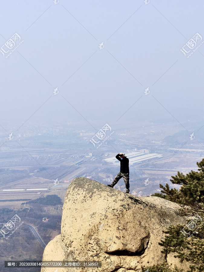 在悬崖上拍照的男人
