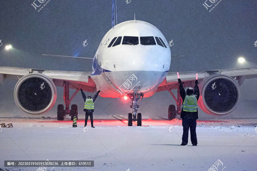 大雪中引导飞机的机务人员