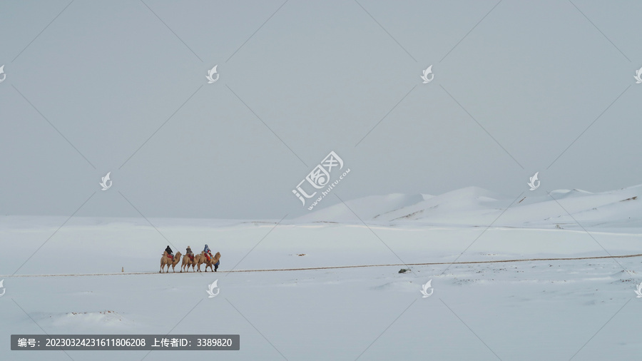 白雪覆盖的鸣沙山与旅人