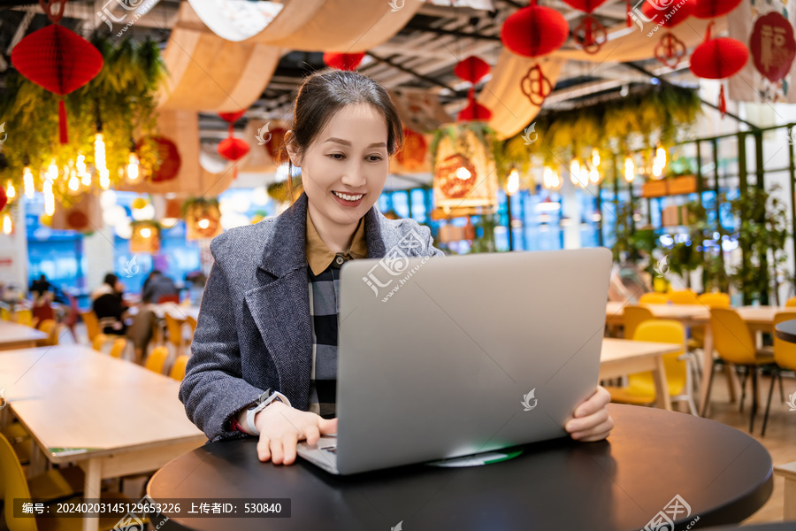 亚洲女性在笔记本电脑前微笑办公