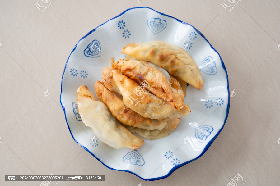 浅色桌面上一盘锅饺煎饺特写