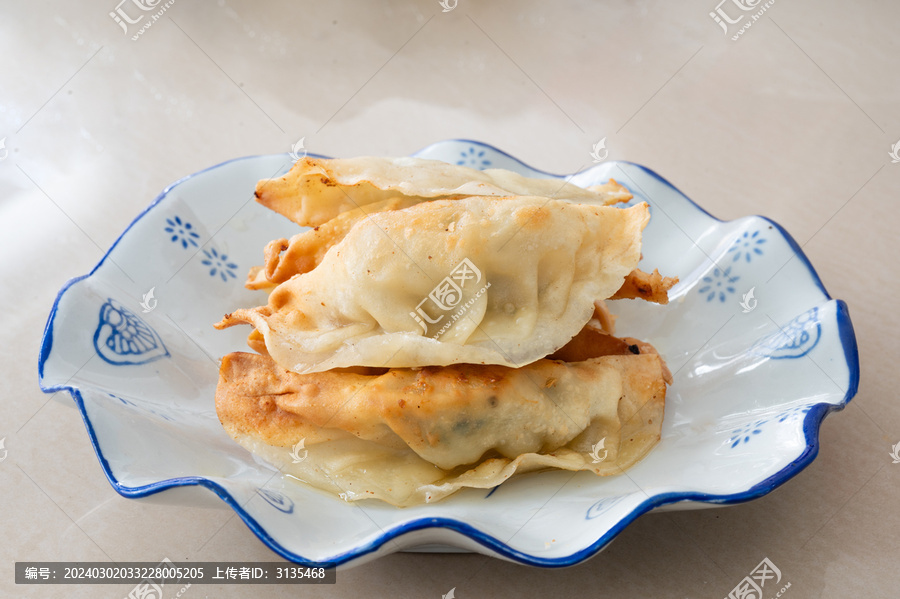 浅色桌面上一盘锅饺煎饺特写