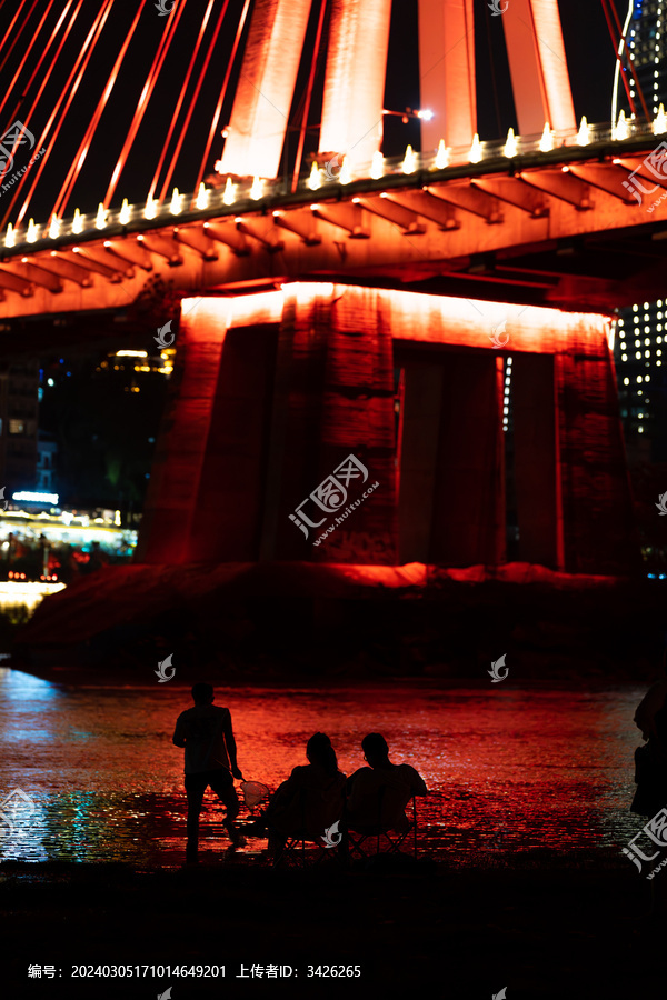 夜晚在澜沧江大桥下玩水的人