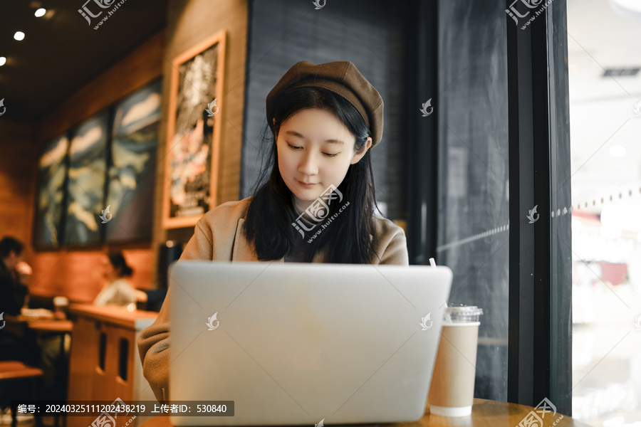 在咖啡店电脑前移动办公的女性