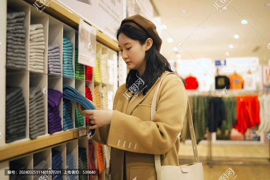 年轻女性在超市货架上选择商品