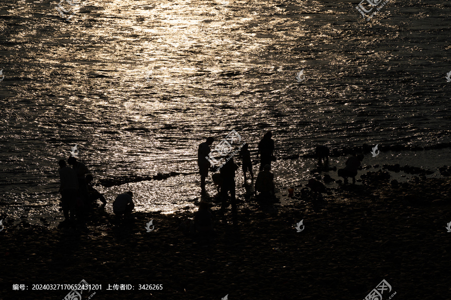 夕阳时在澜沧江边玩水人的剪影