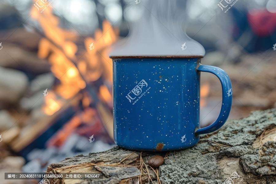在樹林里篝火旁的藍色搪瓷杯里裝著熱飲