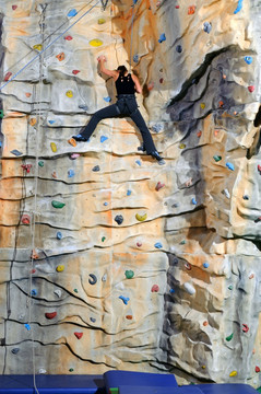 在运动中心里岩石壁上爬的女人