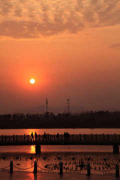 河边栈桥夕阳下的游人