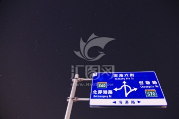 夜空繁星下的高速公路指示牌