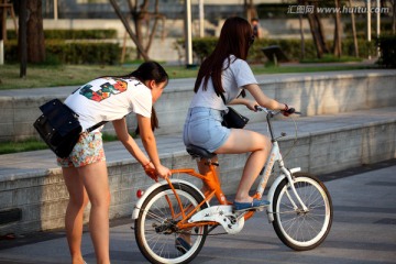 学骑自行车的两个少女
